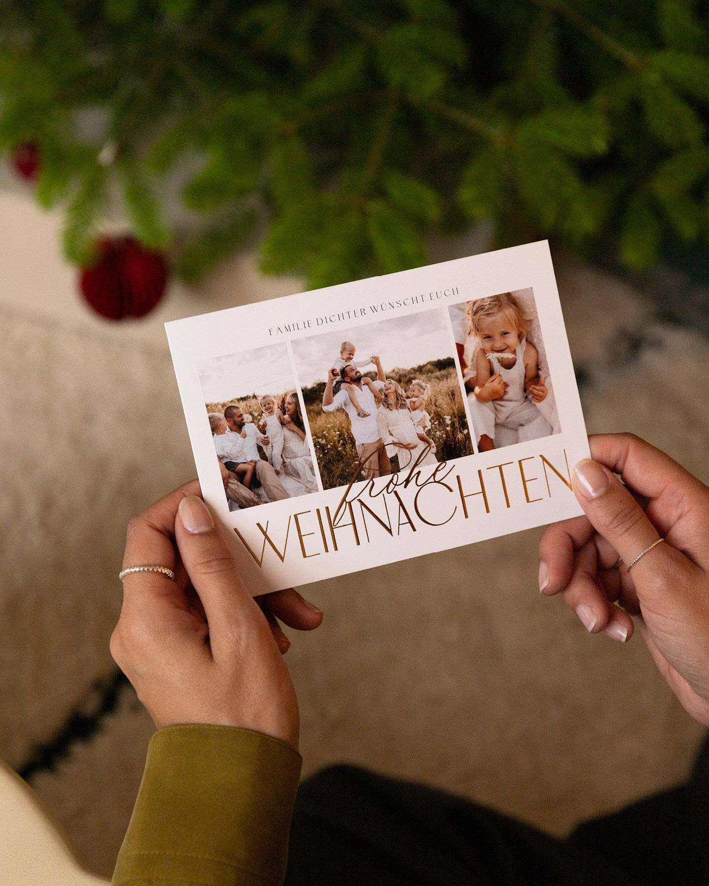 Frau (nicht im Bild) hält schöne Weihnachtskarte in der Hand