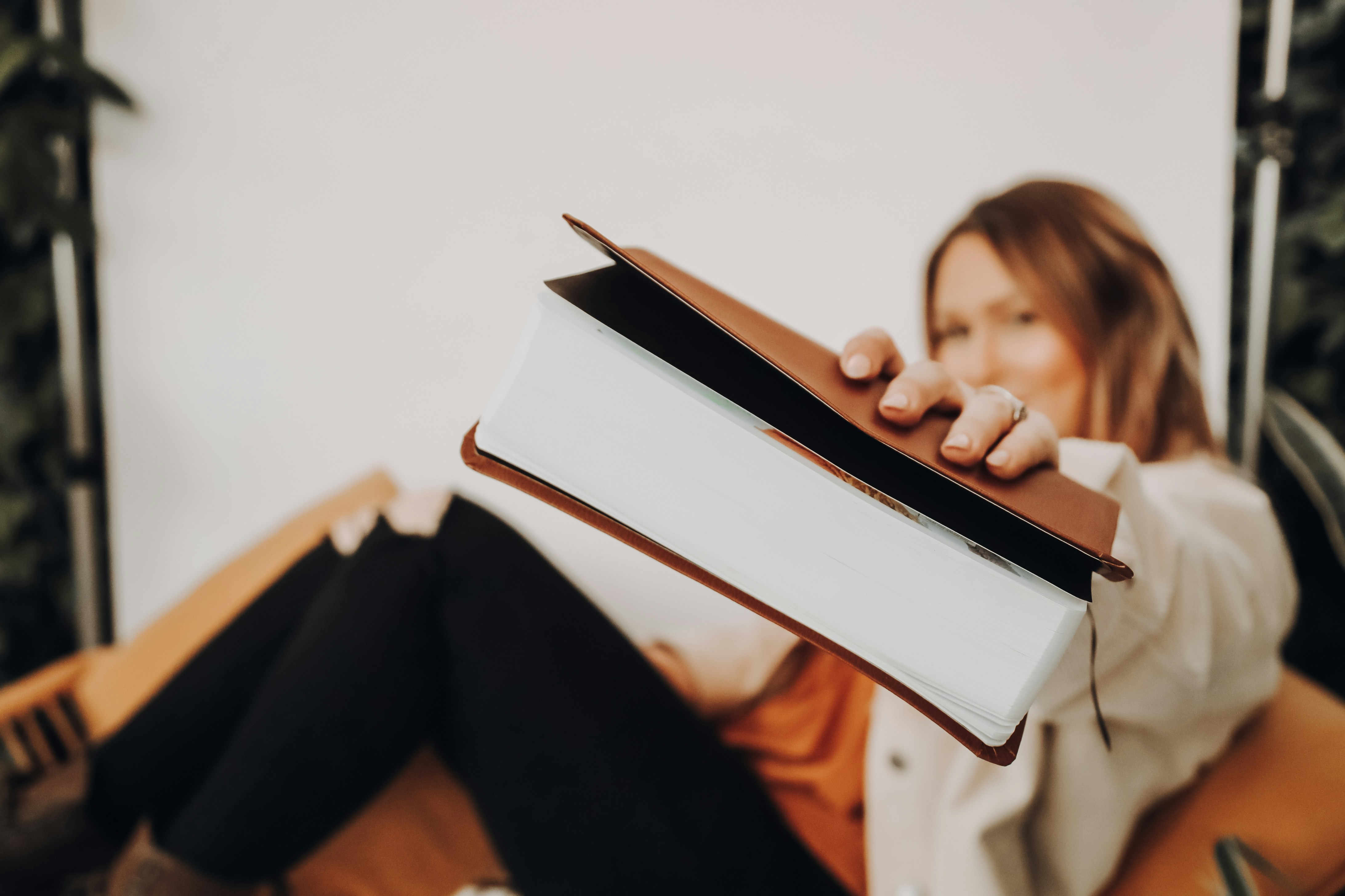 Eine Frau reicht ein Buch zur Kamera