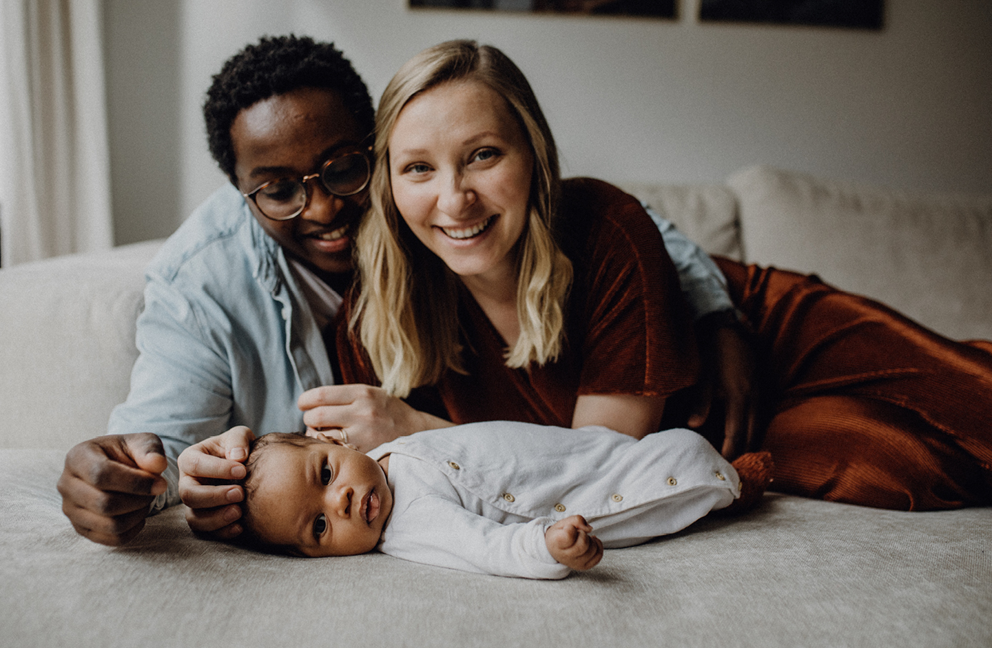 Vater und Mutter kuscheln mit Baby auf dem Bett 