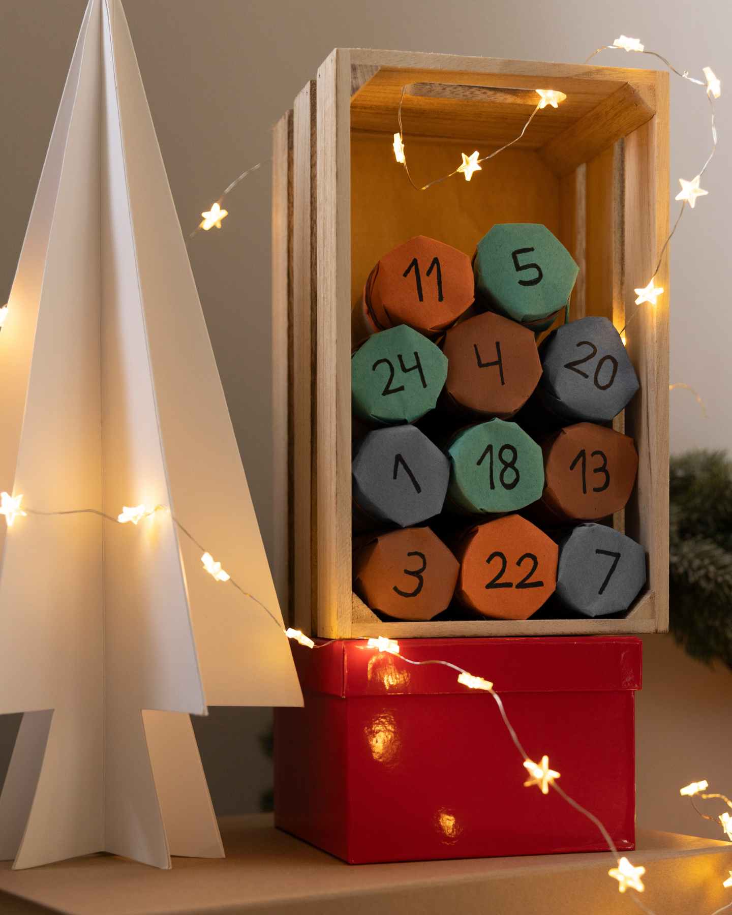 Adventskalender in Holzkiste aus Klorrollen.